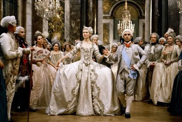 Kirsten Dunst as Marie Antoinette in a wide decorated wedding gown during a royal ceremony