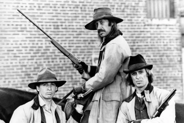 Three Carradine family performers in an older black-and-white western scene
