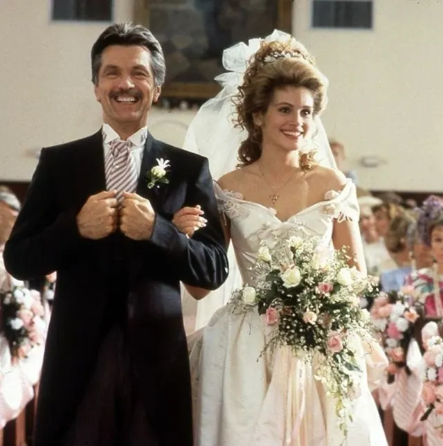 Julia Roberts as Shelby carrying a large bouquet beside her father in Steel Magnolias