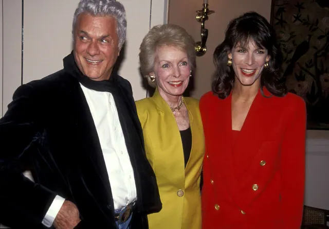Tony Curtis, Janet Leigh in a yellow jacket, and Jamie Lee Curtis in red at an event