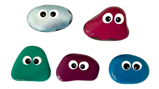 Five brightly painted craft rocks with googly eyes