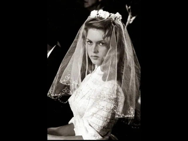 Brigitte Bardot as Juliette wearing a high-necked lace dress and a short veil