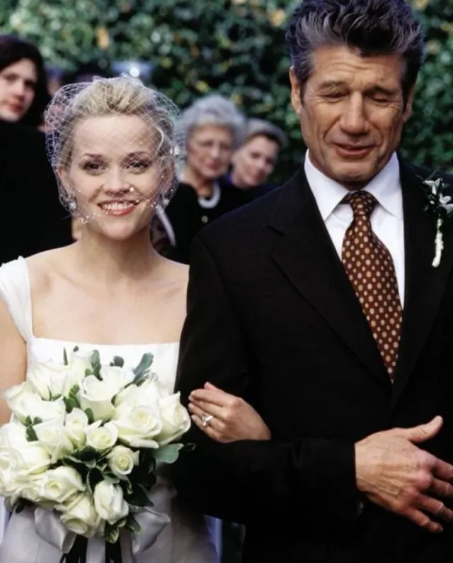 Reese Witherspoon as Melanie wearing a sleeveless bridal dress and short face veil