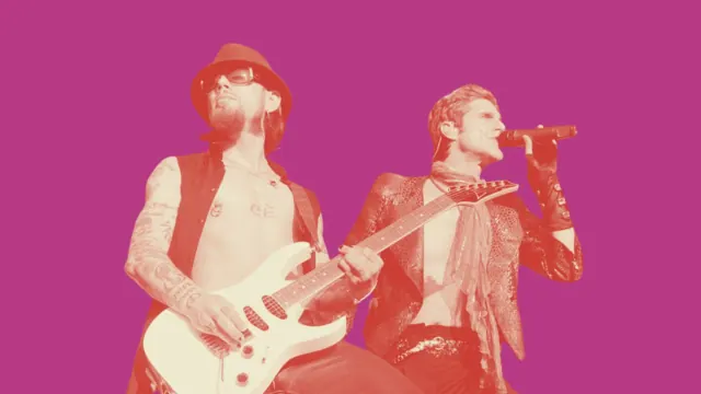 Jane’s Addiction performing onstage under pink lighting