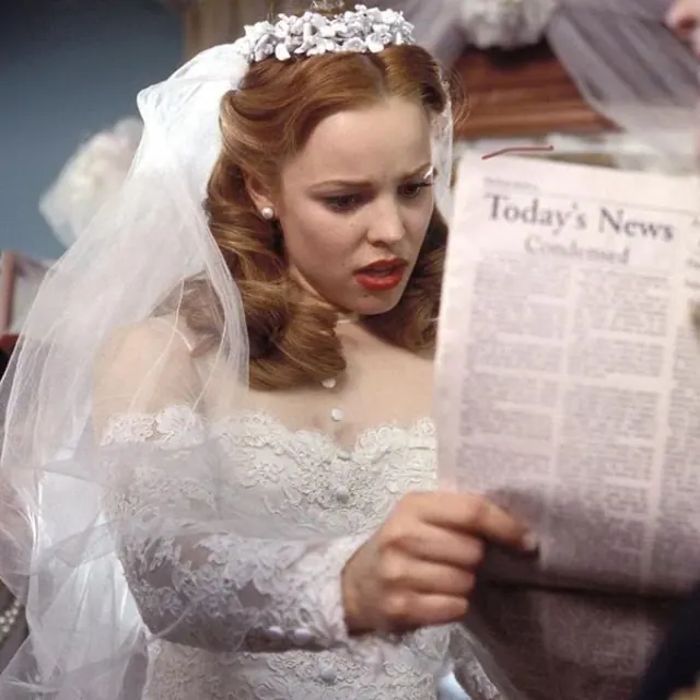 Rachel McAdams as Allie holding a newspaper while wearing a lace wedding dress