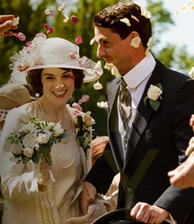 Michelle Dockery as Mary in a hat beside Matthew Goode as Henry at their wedding