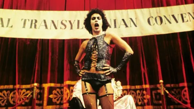 Dr. Frank-N-Furter (Tim Curry) singing a musical number at a party in 