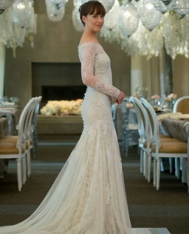 Dakota Johnson as Ana wearing a fitted lace gown with a long train in Fifty Shades Freed