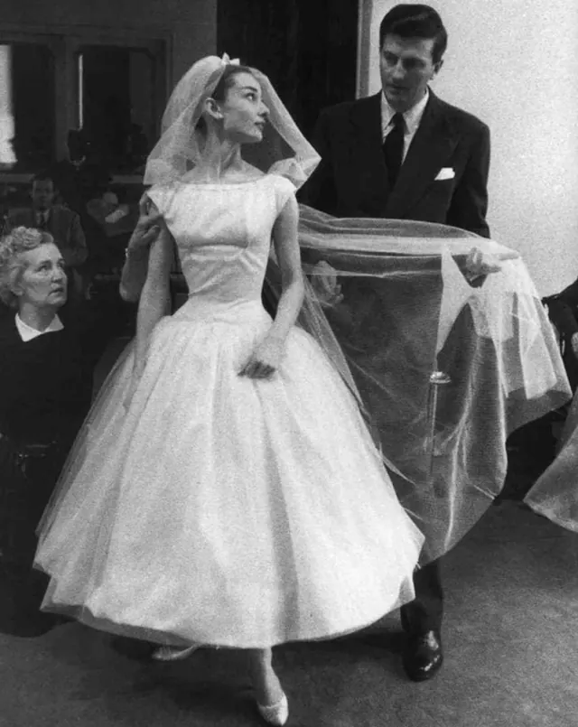 Audrey Hepburn as Jo wearing a short bridal dress beside Fred Astaire in Funny Face