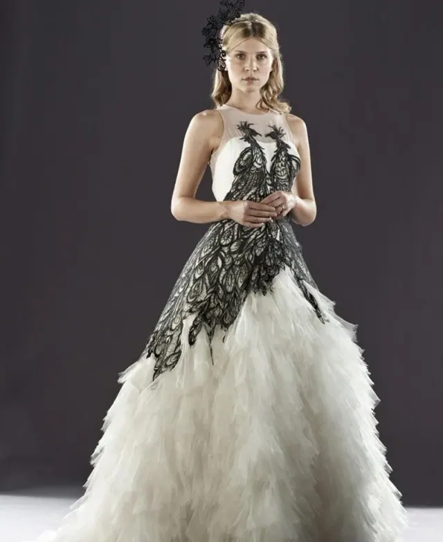 Clémence Poésy as Fleur wearing a white gown with a dark bird pattern