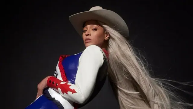 Beyoncé wearing a cowboy hat and holding an American flag