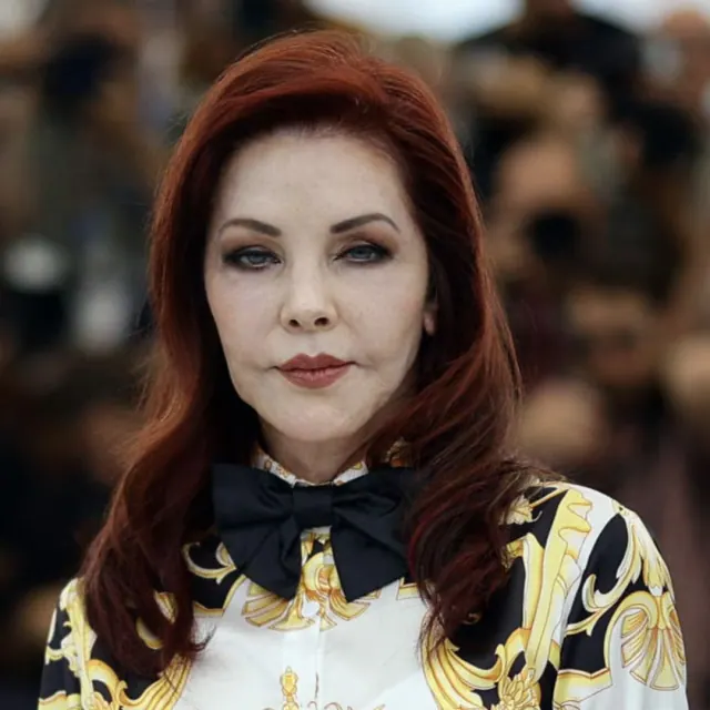 Priscilla Presley with red hair wearing a patterned jacket