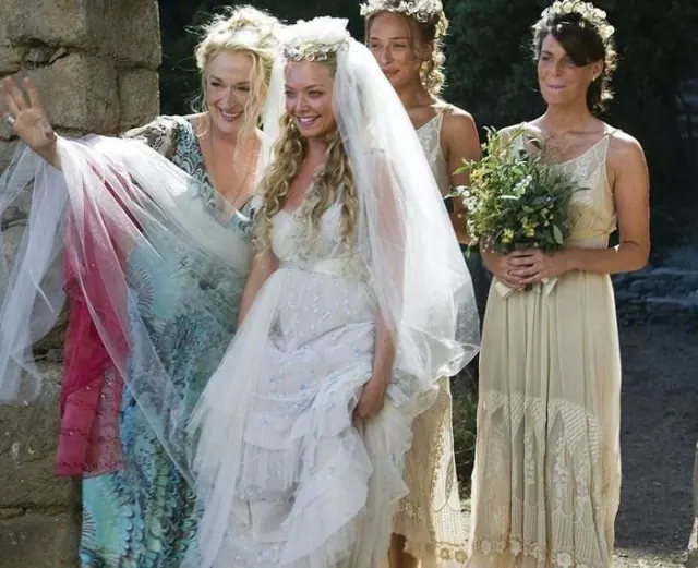 Amanda Seyfried as Sophie in a tiered bridal gown and veil among her bridesmaids