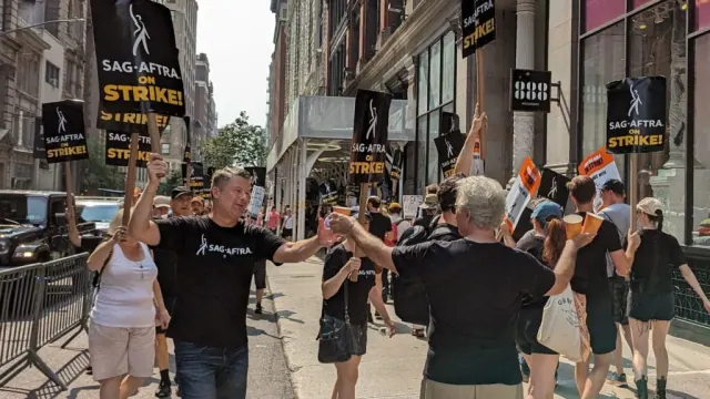 SAG-AFTRA demonstrators holding strike signs on a city street