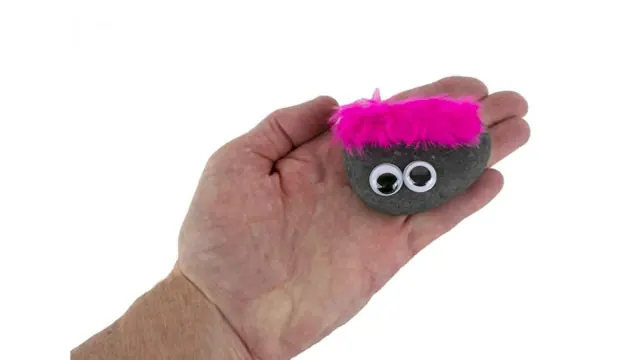 Small pink-haired novelty rock held between fingers