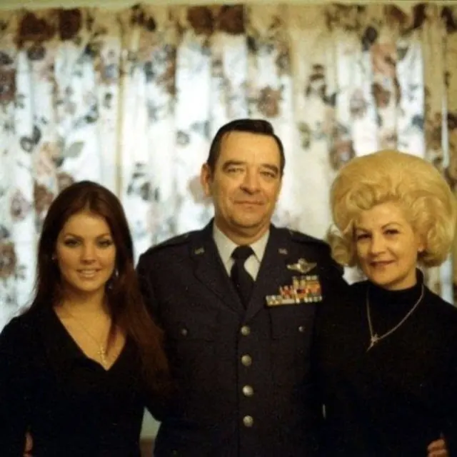 Priscilla with two adults, including a man in military uniform