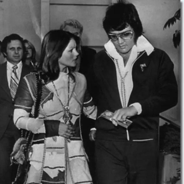 Priscilla and Elvis walking together outside court