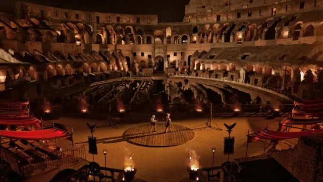 Two gladiators dueling in the middle of the Colosseum at night.