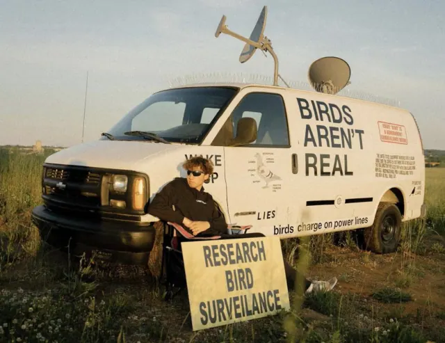 Peter McIndoe beside the decorated Birds Aren't Real van